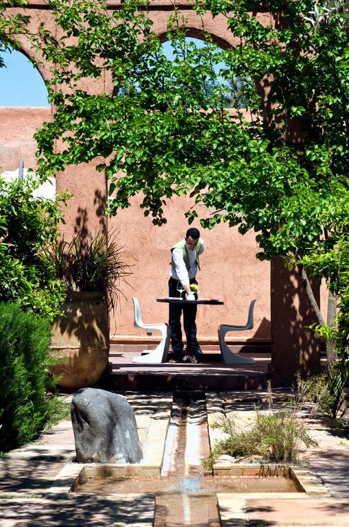 티그미자 스위트 앤 파빌리온 호텔 Ouled Jelal 외부 사진 A student studying in the courtyard of the library